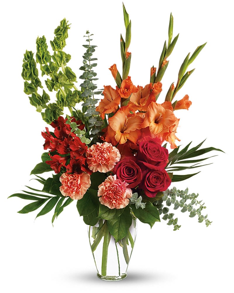 Tall bouquet of orange gladiolus, red roses, and carnations in a clear vase
