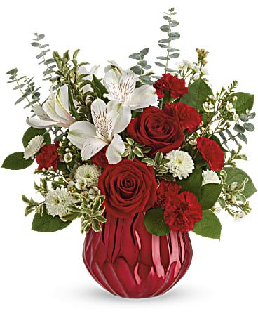Red and white floral arrangement in a red vase
