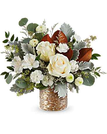 White roses and small white flowers in a woven basket vase