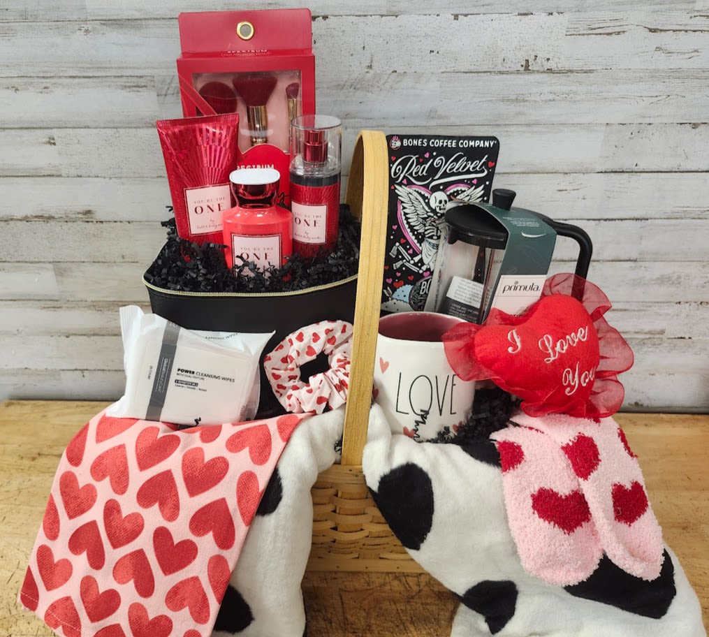 Gift basket with heart-patterned blankets, mug, candles, and beauty items
