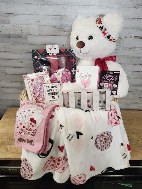 Gift basket with a teddy bear, cards, and heart-themed blankets