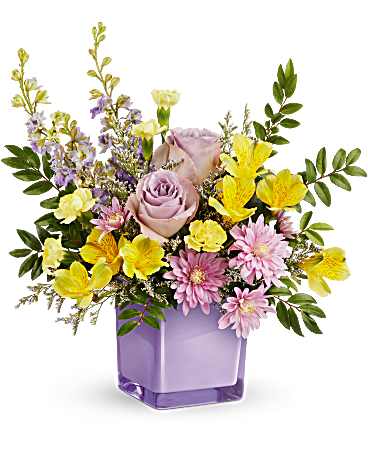 Lavender and yellow mixed flower arrangement in a purple glass vase