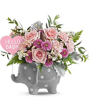 Pink roses and purple flowers in a gray elephant planter with a "Hello Baby" sign