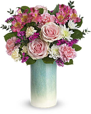 Pink roses and mixed blooms in a tall blue vase