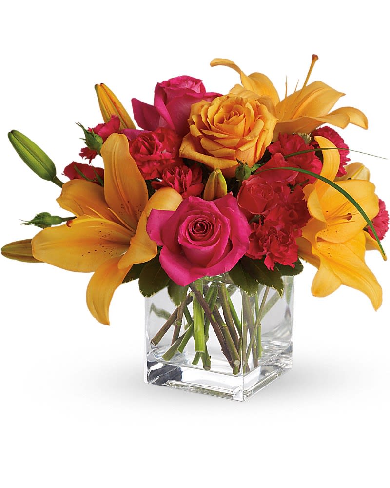 Pink roses and yellow lilies arranged in a clear glass vase