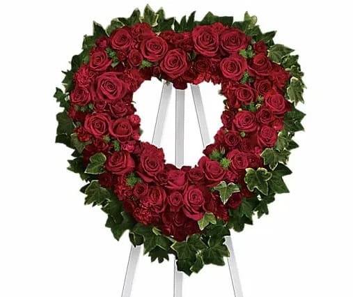 Heart-shaped wreath of red roses on a stand