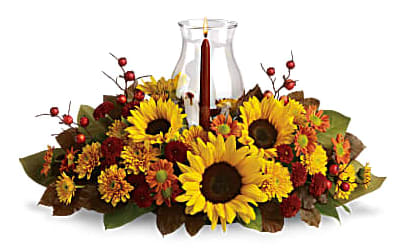Sunflower and autumn flower centerpiece around a glass candle holder