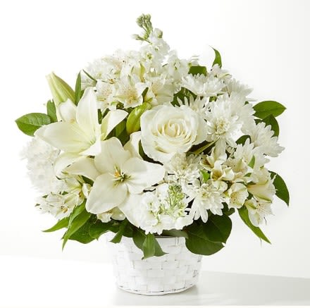 White flowers arranged in a clear basket vase