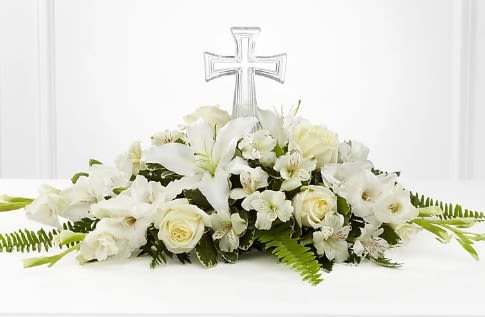 White floral casket spray with a clear cross topper