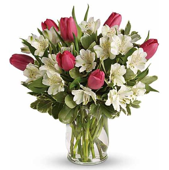 Spring Romance Bouquet - Spring is the season for romance! Brimming with exquisite tulips and alstroemeria, this bouquet in a classic glass hurricane celebrates the beauty of the season. -Includes pink tulips, white alstroemeria and variegated pittosporum. -Delivered in a glass hurricane vase. -Orientation: All-Around