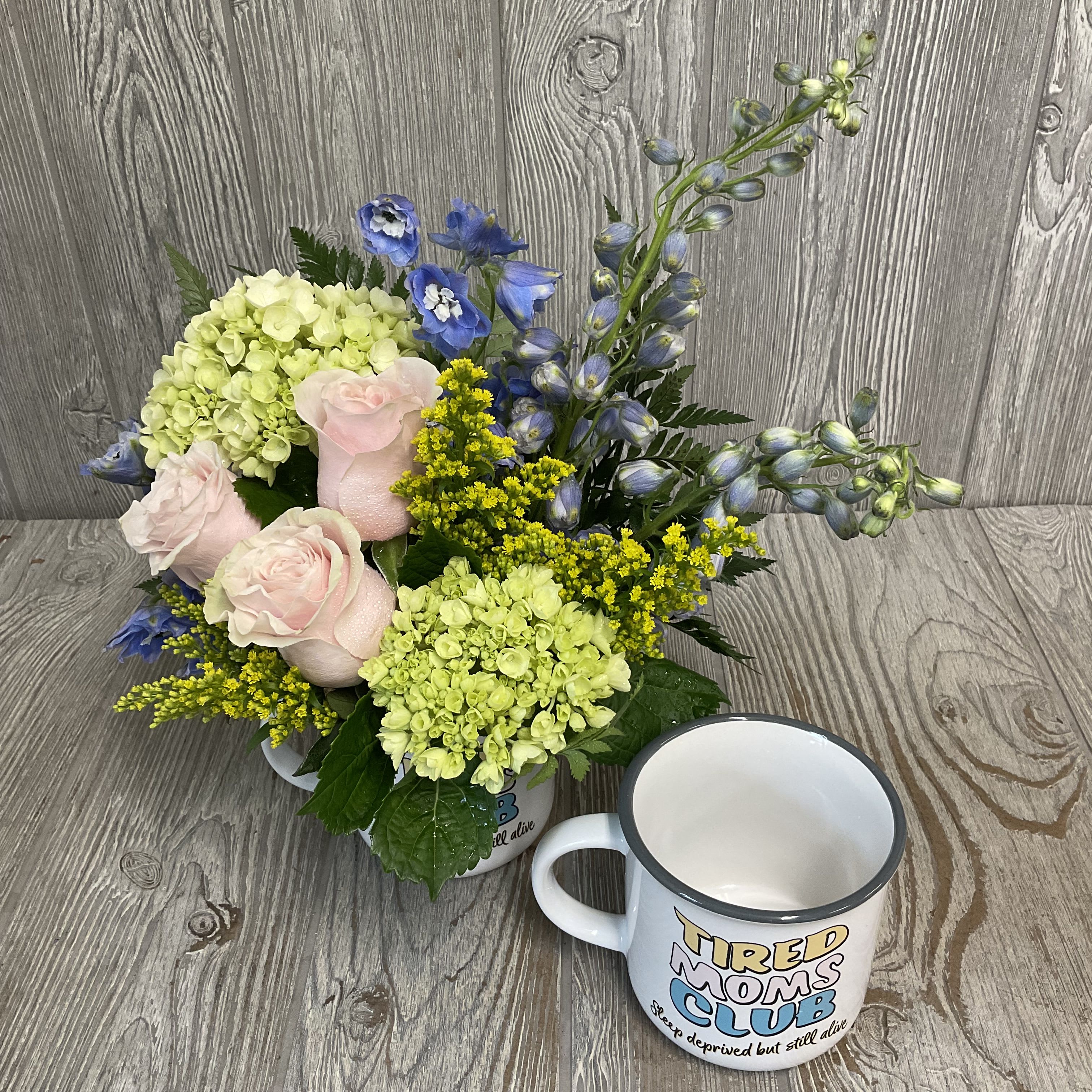Tired Moms Club  - A soft floral arrangement in a relatable keepsake mug. Makes a great gift for the hardworking mom in your life. Colors and flowers may vary.