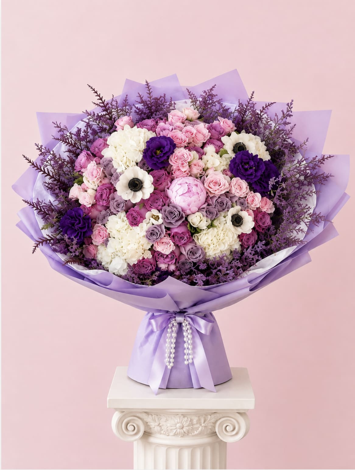 Lavender and pink bouquet with roses, hydrangeas, and white anemones in purple wrap