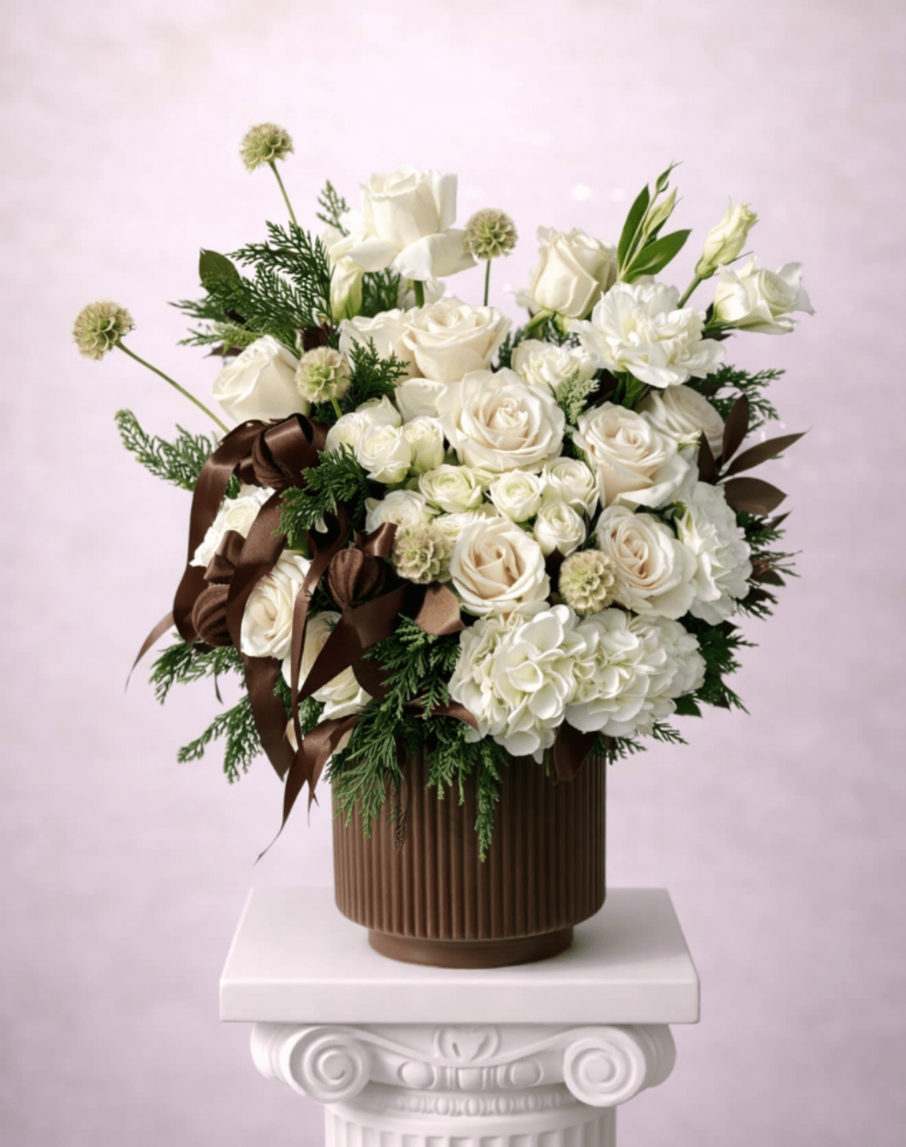 White rose arrangement in a brown ribbed vase with dark ribbon accents