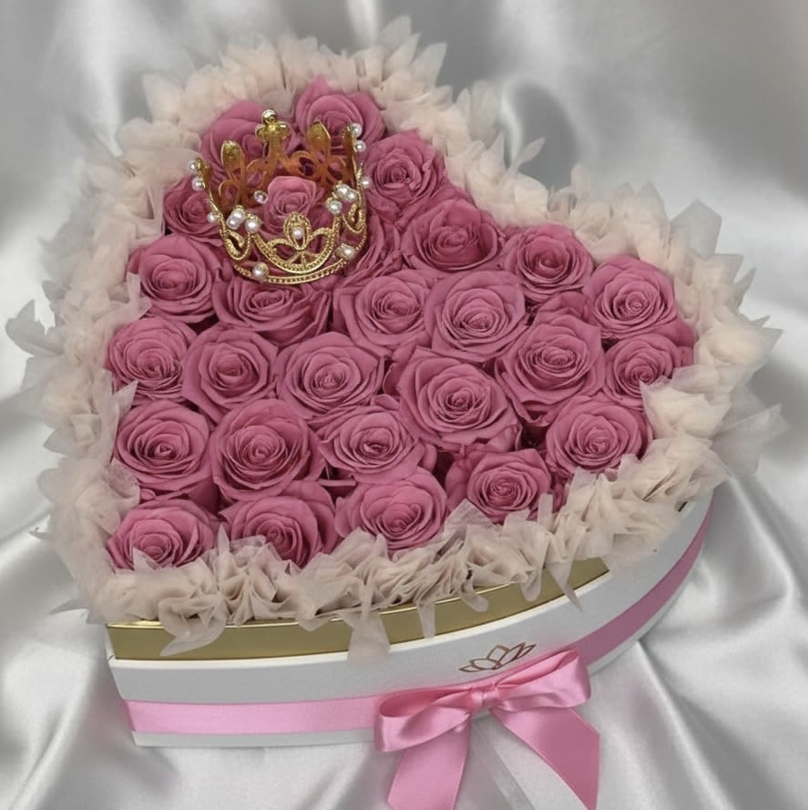 Heart-shaped box of pink roses with a small crown topper