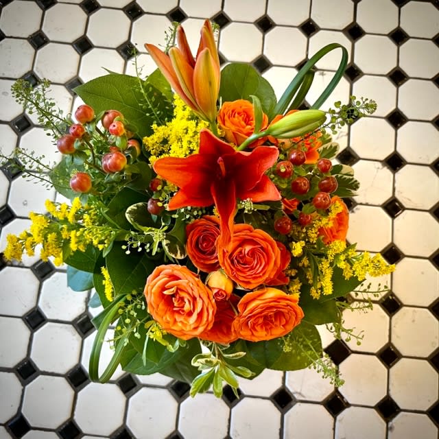 Citrus Crush - Citrus crush combines Yellow, Orange and Green into a beautiful and stunning combination. Includes Lillies, Berries, and spray roses with unusual foliage in a design perfect for any home or office space. This arrangement is approximately 9.5in by 9.5in.