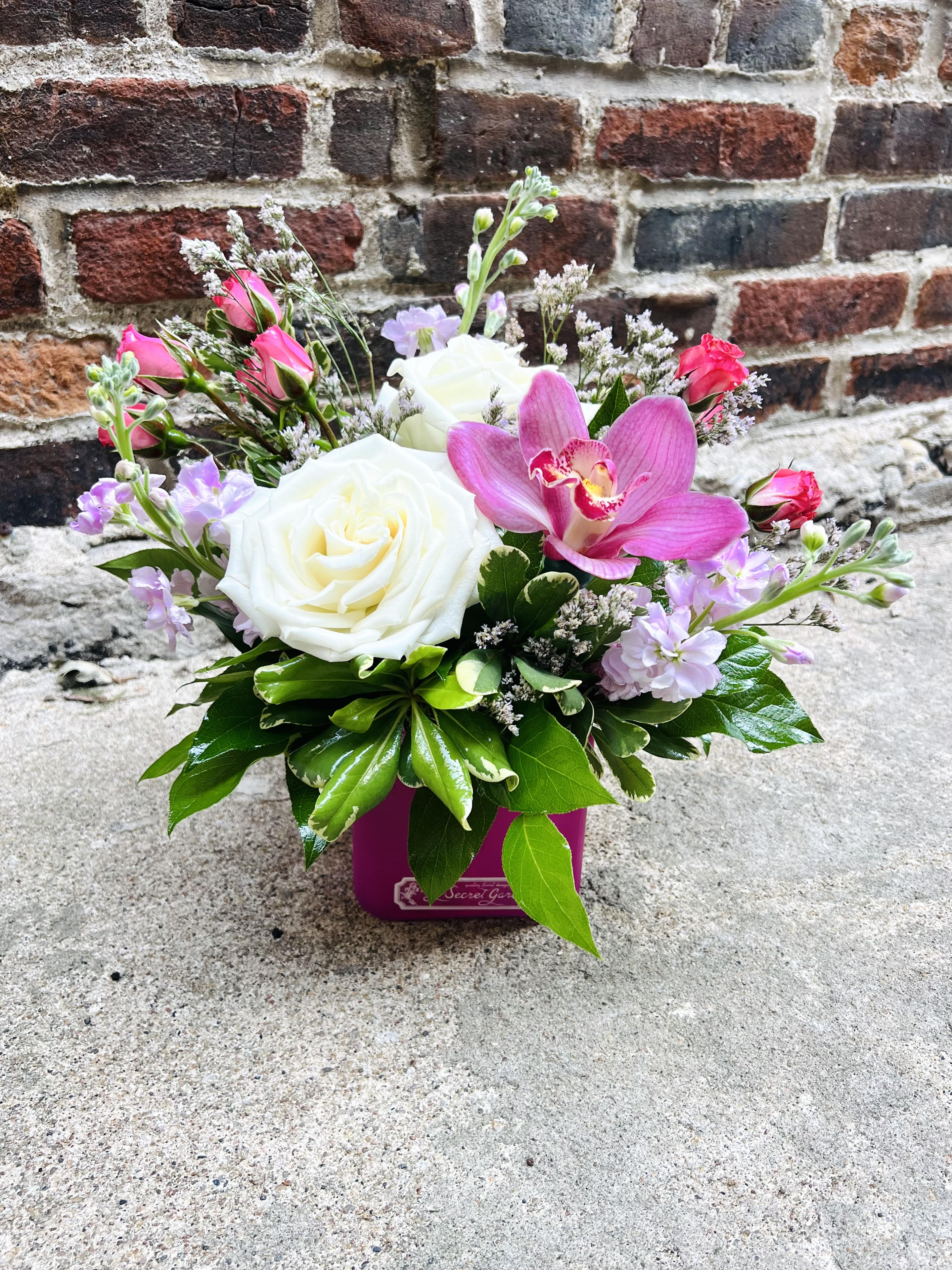 Strawberry Shortcake  - "Strawberry Shortcake" Features beautiful and romantic colors of soft pinks and whites. Including white Roses, Stock, and a Cymbidium orchid. This gorgeous design is perfect for the home or office space.  This arrangement sits approx: 11 inches tall and 9 inches wide. 
