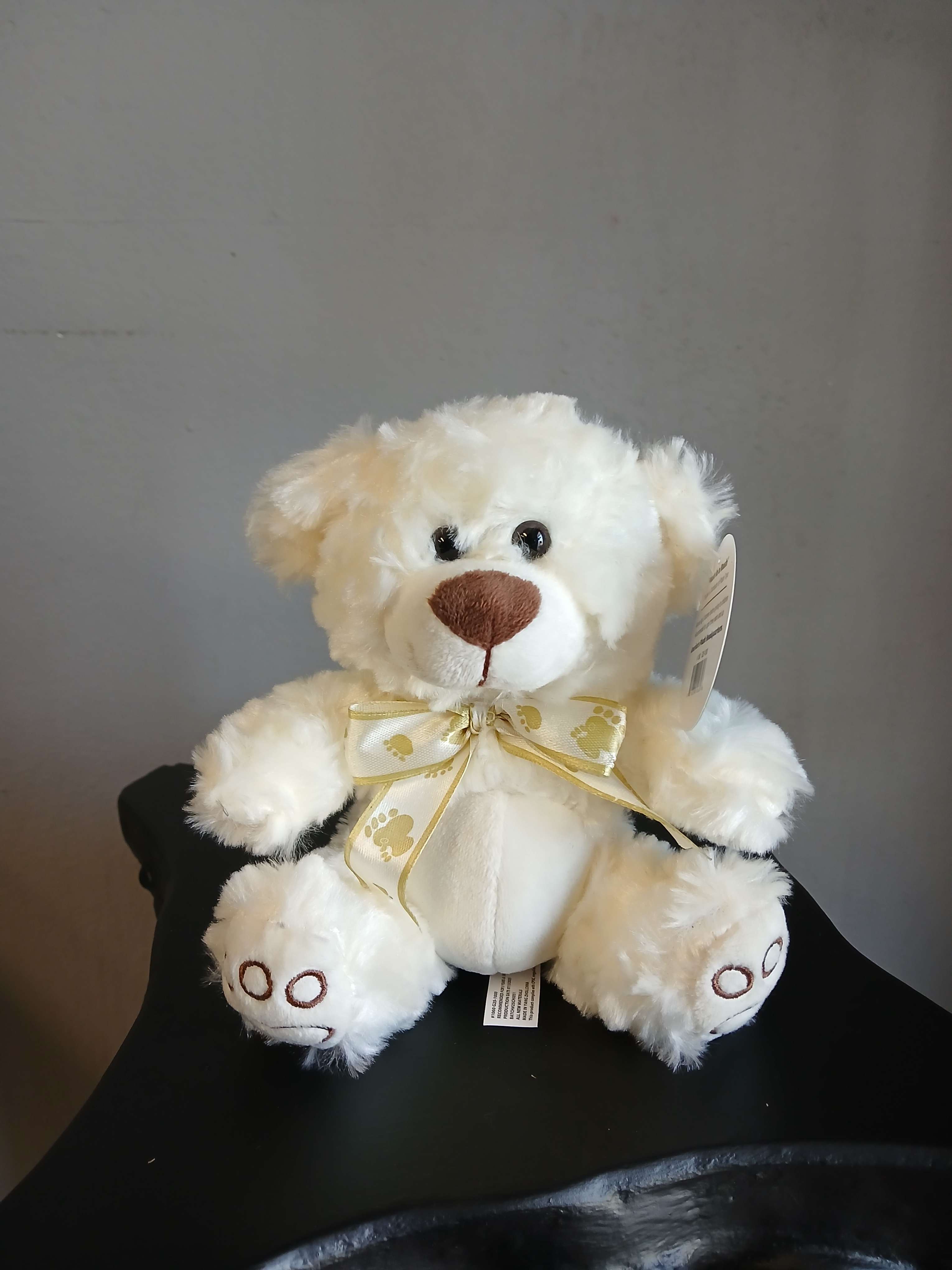 White plush teddy bear with a gold ribbon bow