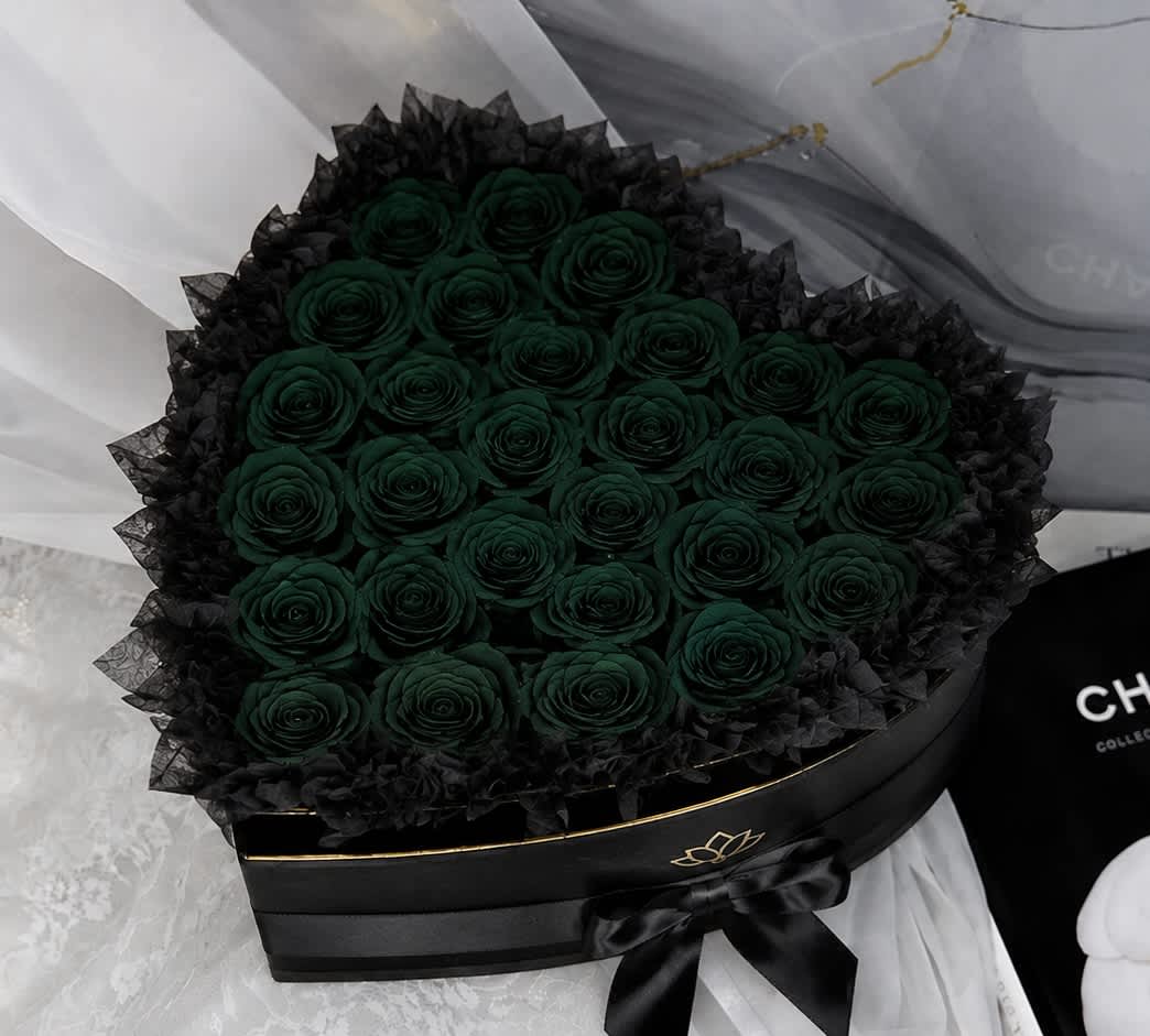 Round bouquet of dark green roses in a black box with a ribbon