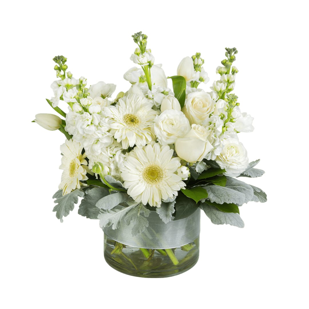 Purity  - This arrangement contains gerbera daisies, roses, tulips, stock, and other seasonal blooms. 