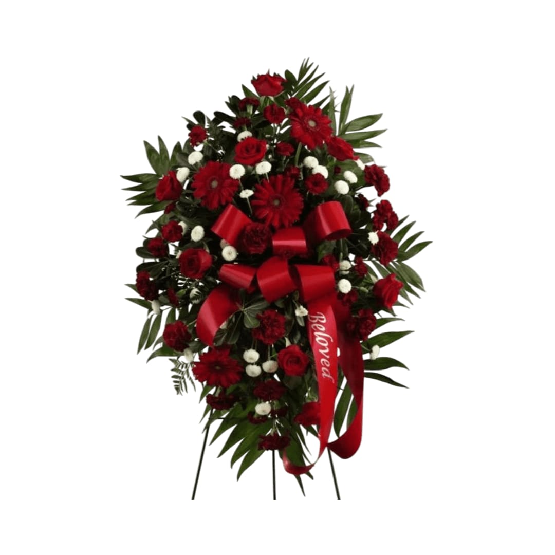 Treasured Memories Standing Spray - Treasured Memories Standing Spray is a rich and colorful way to express your unending love and devotion to the departed. An exceptional arrangement of red roses, burgundy carnations, burgundy minicarnations, red gerbera daisies and white button poms are accented with  a variety of lush greens. A red ribbon with the word, ""Beloved," embossed in a gold metallic lettering, finishes this beautiful display for their final farewell service. Displayed on a wire easel.  Note in special instructions the script request. (ex. Beloved, Mom, Brother, Son etc."   