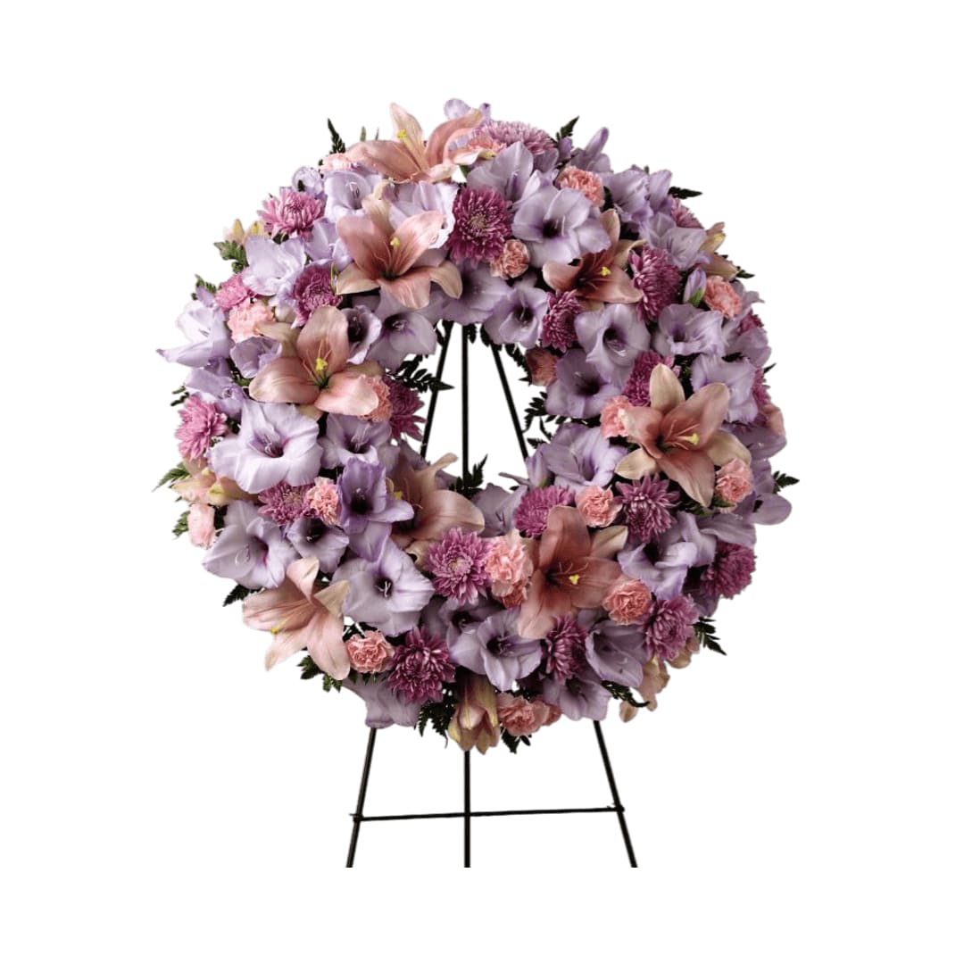 Sleep in Peace Wreath - Sleep in Peace Wreath is a soft expression of sympathy  that will bring comfort and offer hope during the final farewell.  Lavender gladiolus, pink Asiatic lilies, lavender chrysanthemums, pink  mini carnations and lush greens are beautifully arranged in the form of a  wreath for a sweet and colorful look. Displayed on a wire easel, this  wreath is a lovely way to honor the life of the deceased.    
