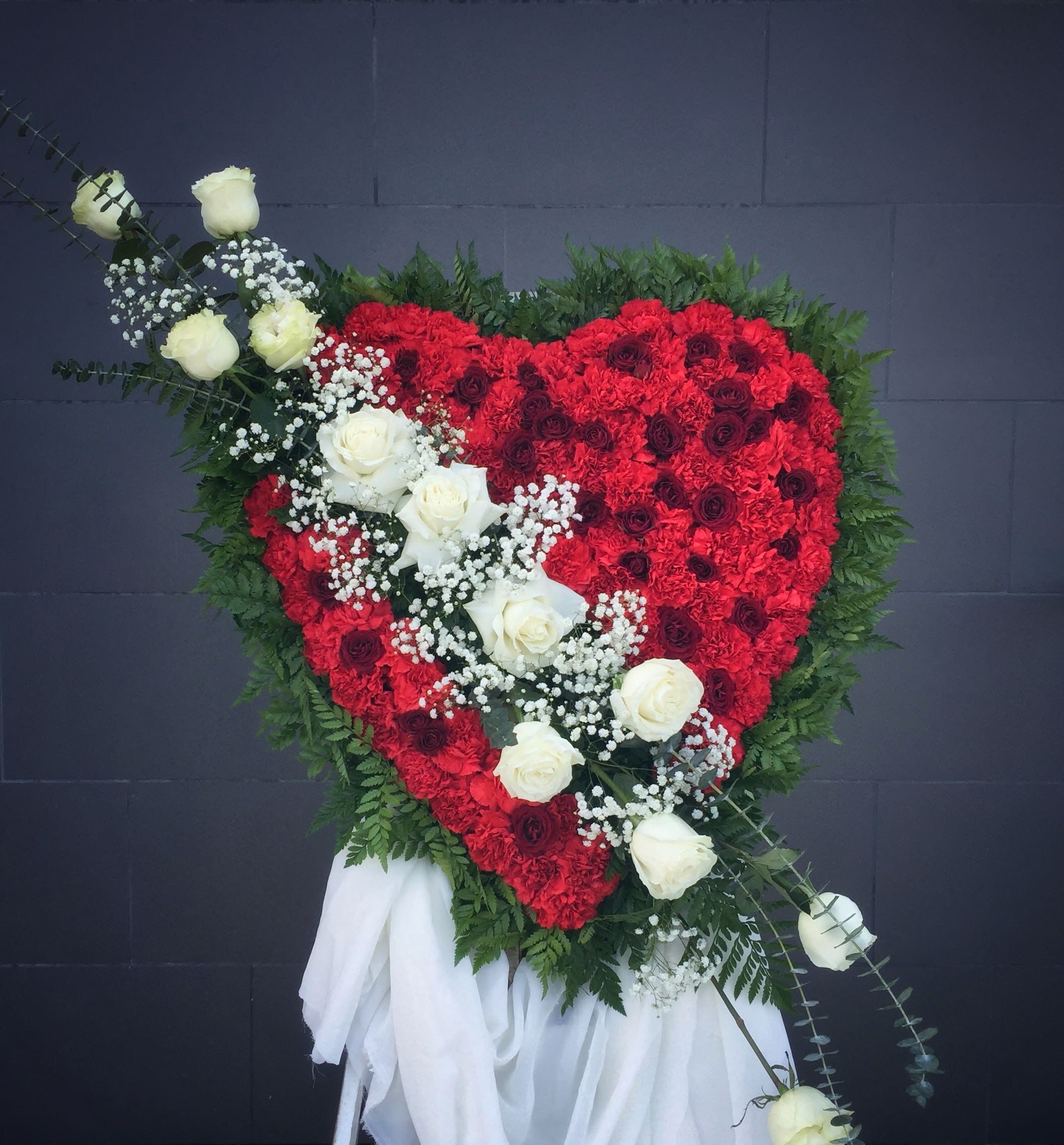 Heart-shaped red floral spray with white roses and greenery