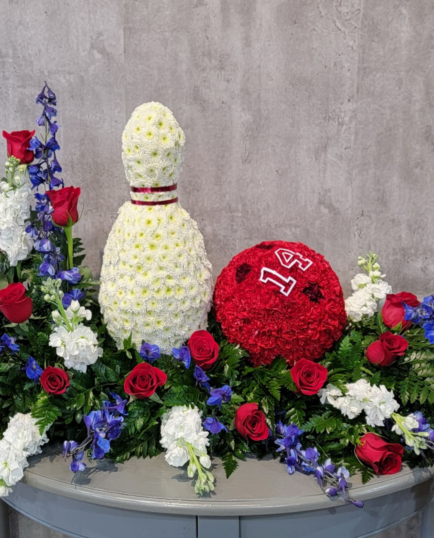 Floral display with a white bottle shape and a red round floral piece
