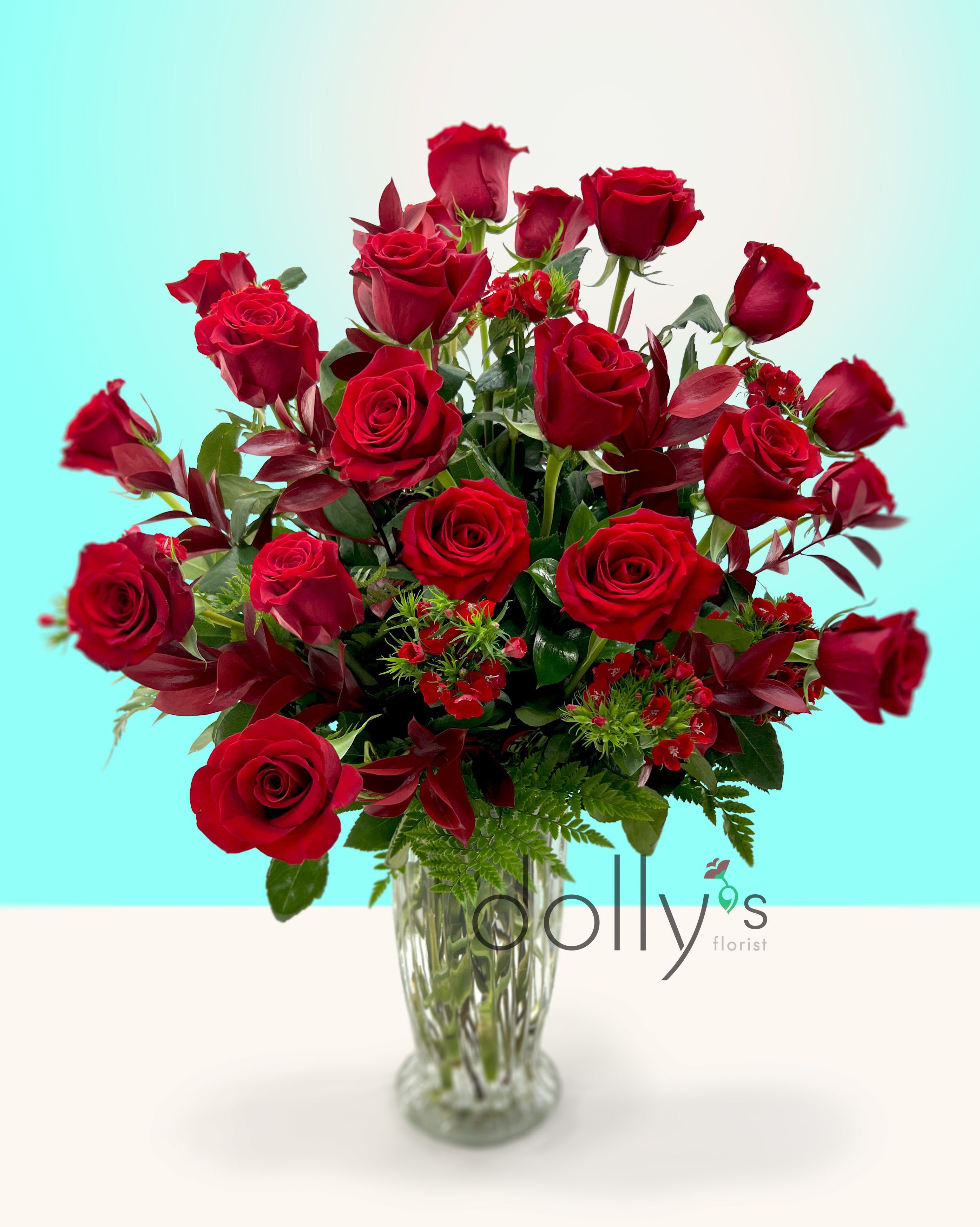 Red roses arranged in a clear glass vase