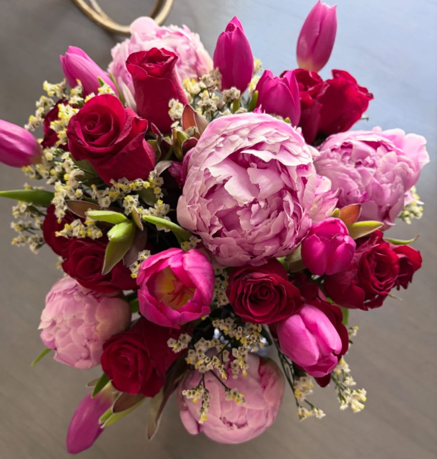 Bouquet of pink peonies, red roses, and magenta tulips