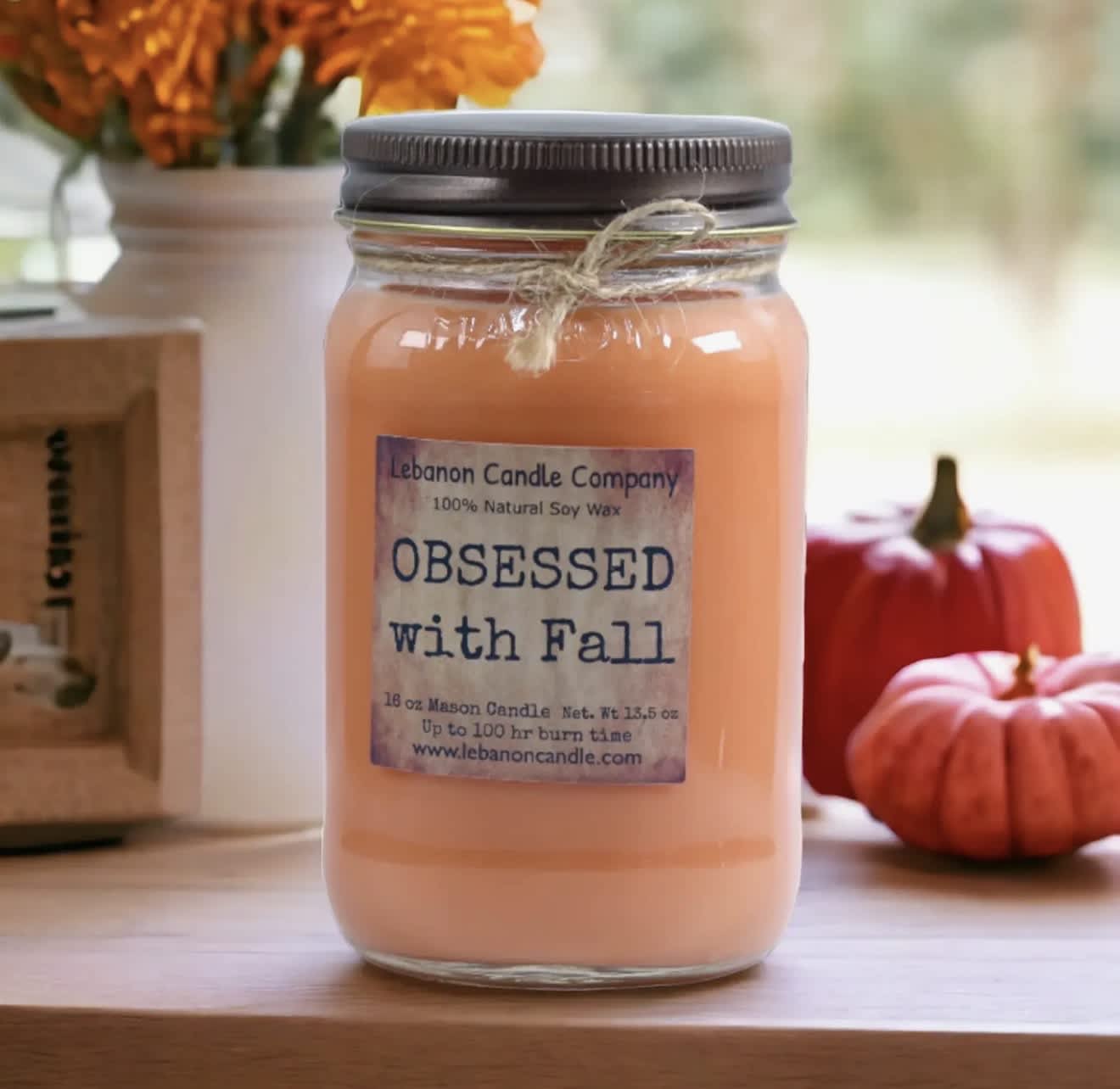 Orange candle in a mason jar with a fall label and twine tie