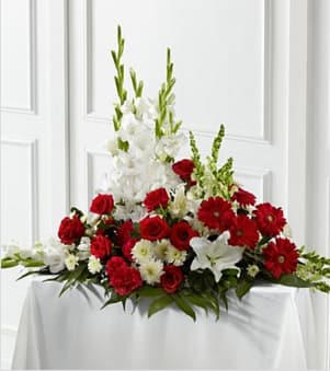 The FTD Crimson &amp; White Arrangement - The FTD® Crimson &amp; White™ Arrangement is a lovely symbol of peace and love. Red roses, carnations and gerbera daisies pop against the white blooms of gladiolus, snapdragons, Oriental lilies and chrysanthemums. Accented with a variety of lush, vibrant greens, this exquisite arrangement is a beautiful tribute to the deceased. Approximately 30"H x 40"W. Your purchase includes a complimentary personalized gift message.