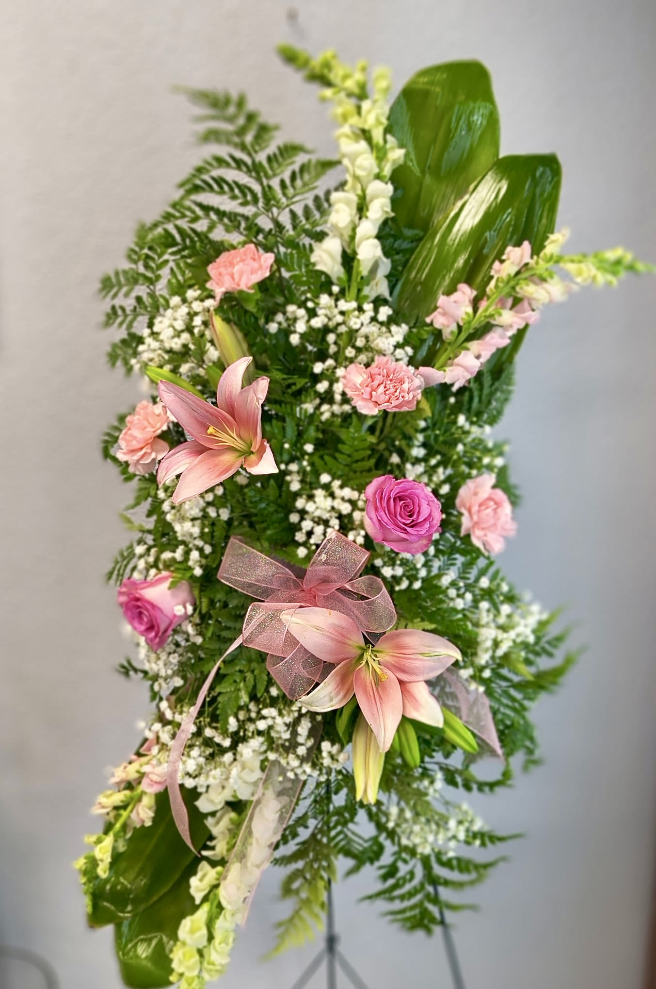 Tall floral standing spray with pink lilies, roses, and carnations