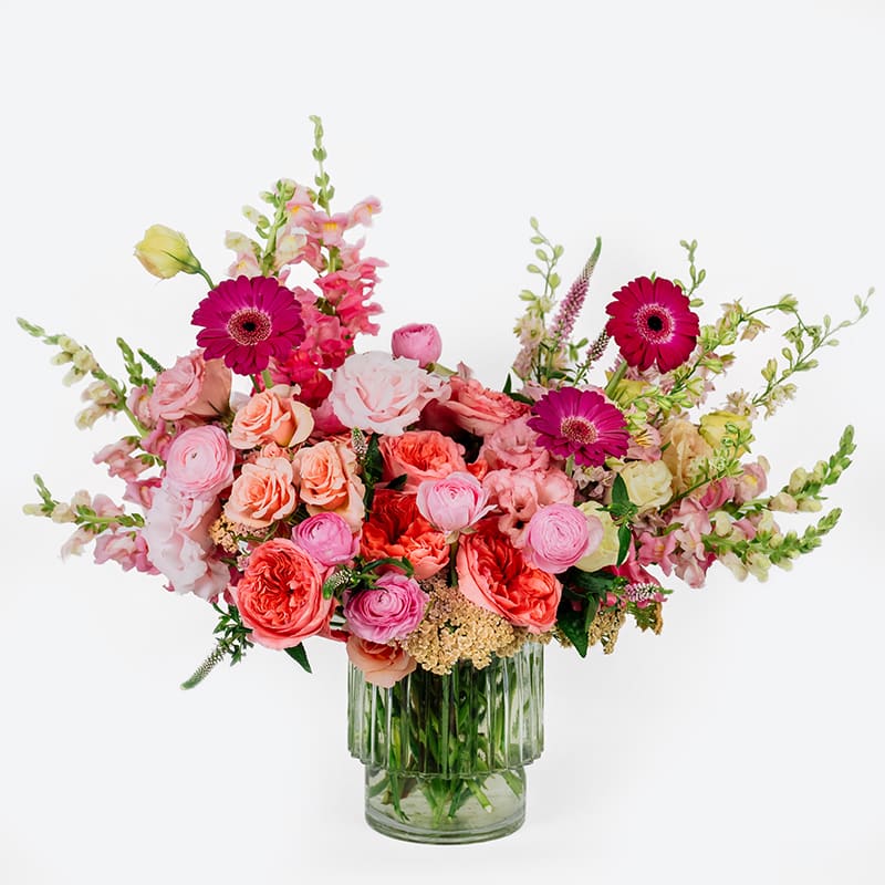 Pink and coral mixed bouquet in a clear glass vase