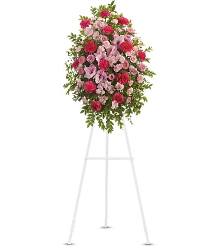 Pink and red floral standing spray on a white easel