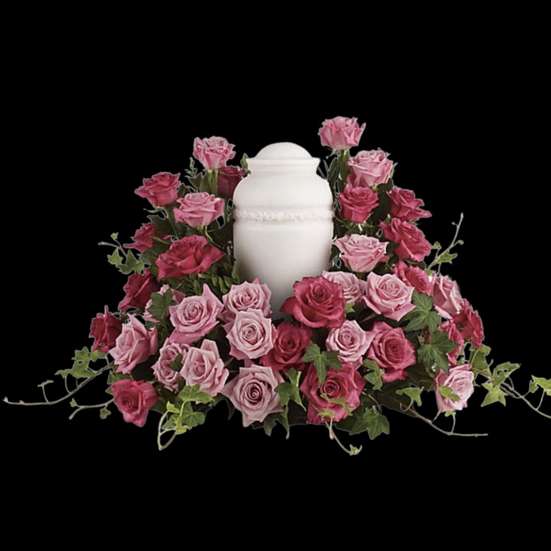 Pink roses arranged around a white urn on a black background