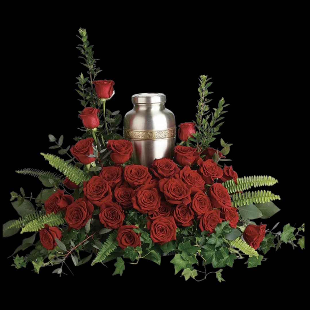 Red roses arranged around a silver urn with greenery