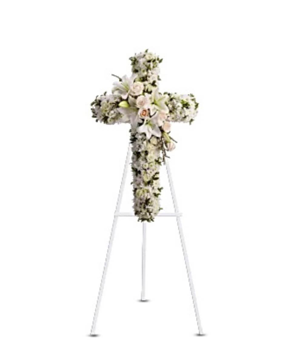 White floral cross arrangement on a standing easel