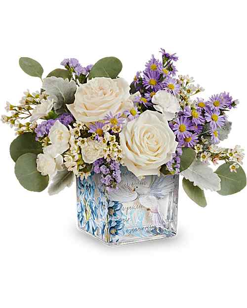 White roses and purple daisies in a square glass vase