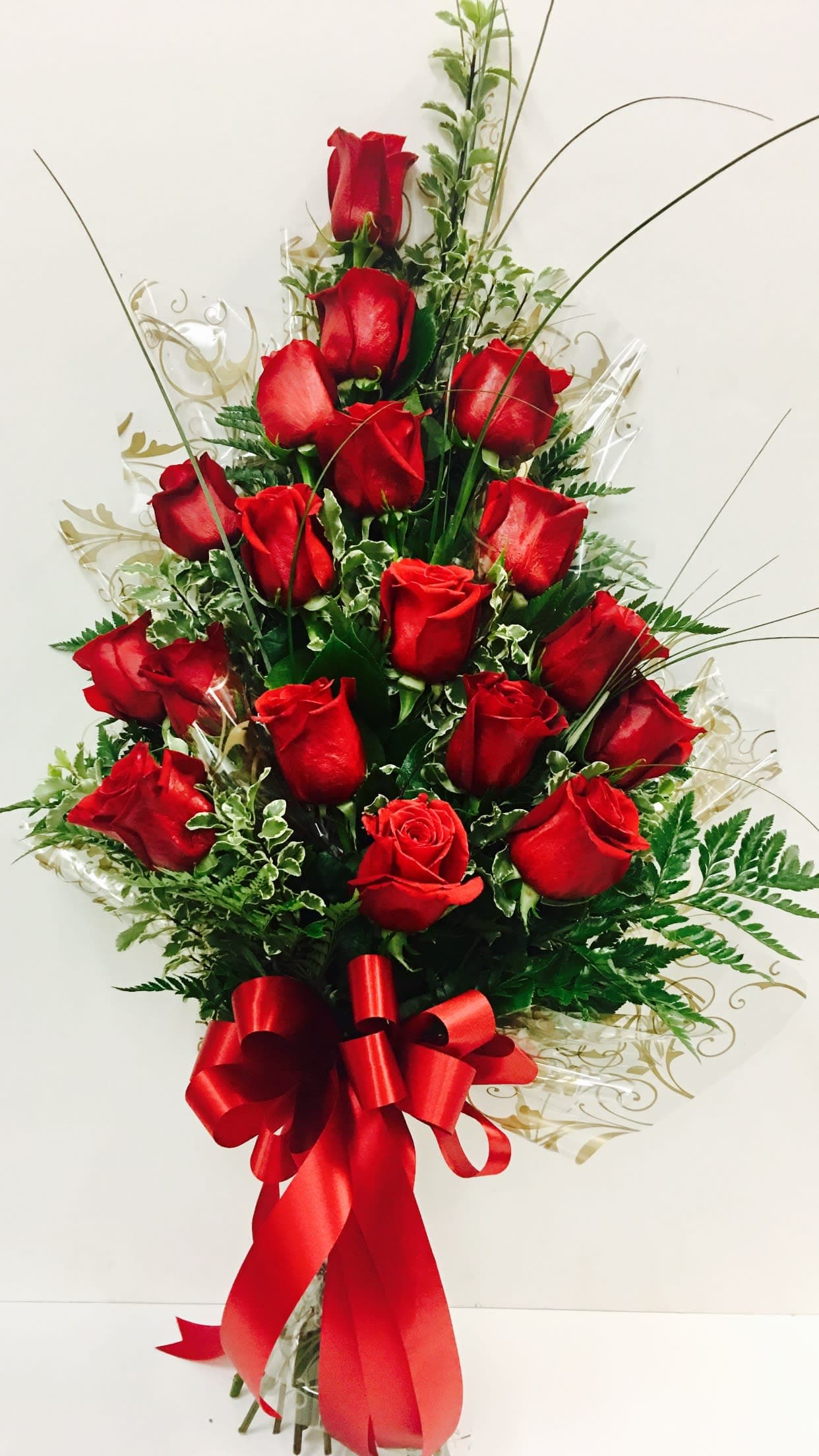 Tall bouquet of red roses with a red ribbon bow