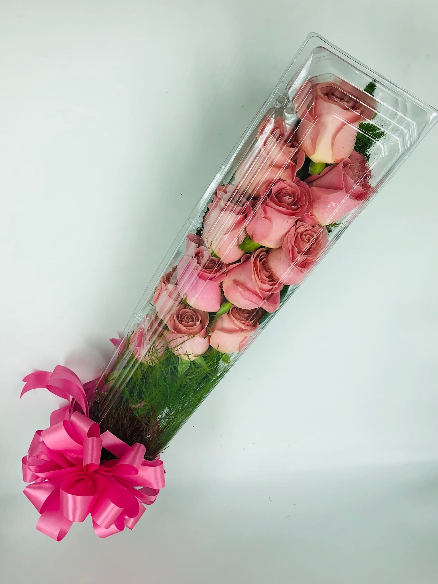 Long box of pink roses with a bright pink ribbon bow