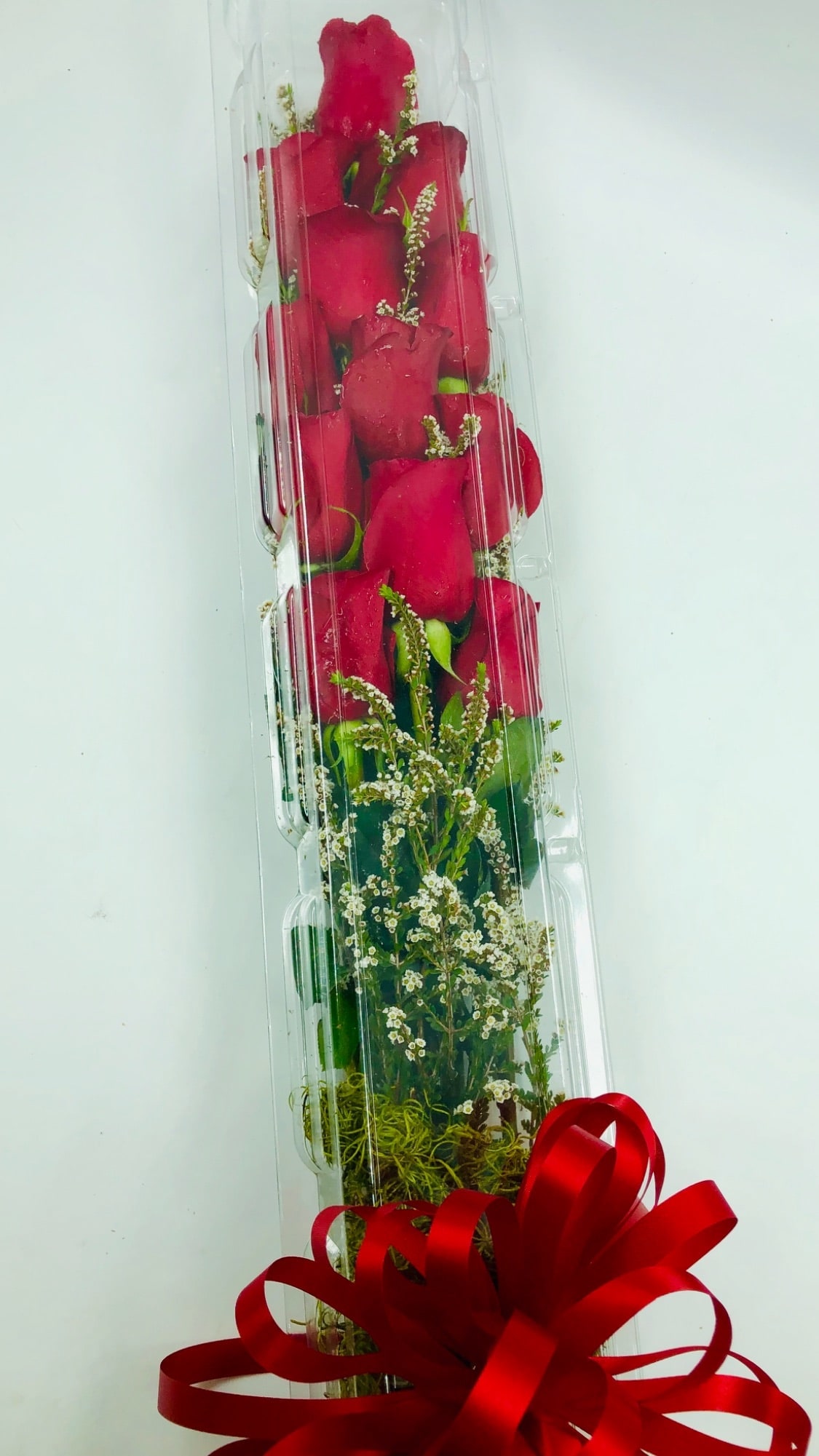 Tall box of red roses with a red ribbon bow