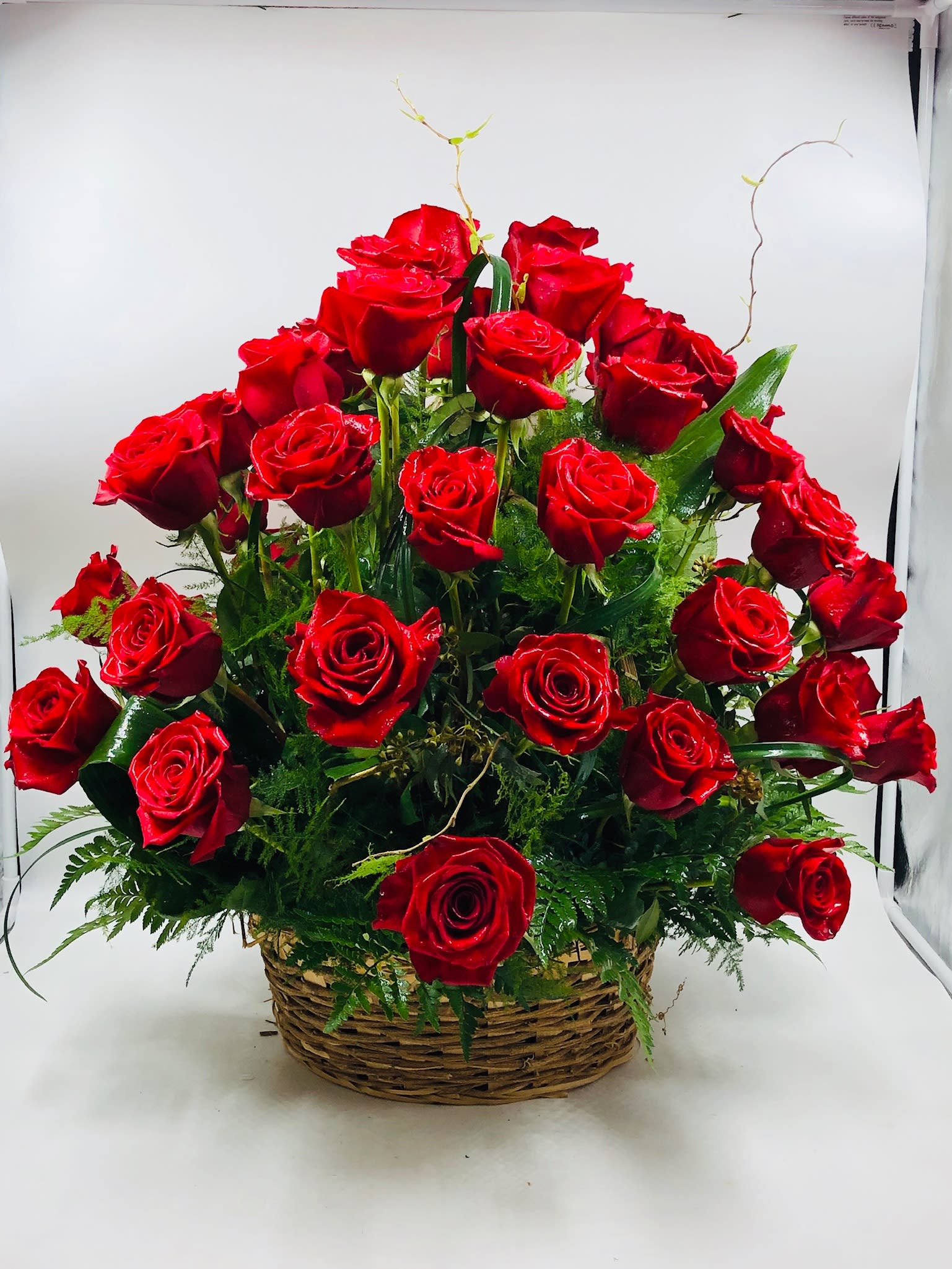 Basket of red roses with greenery