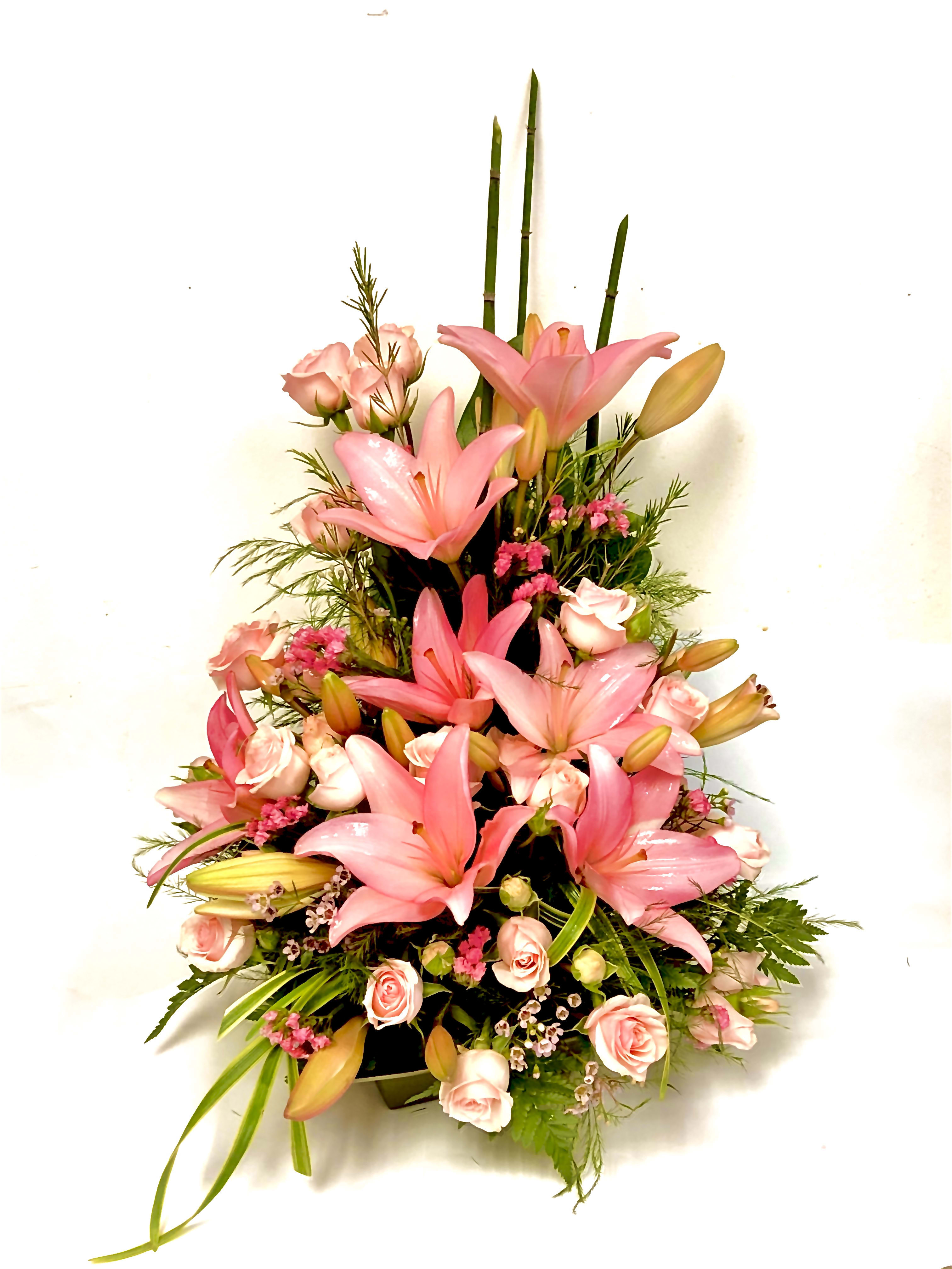 Pink lilies and roses arranged in a tall bouquet
