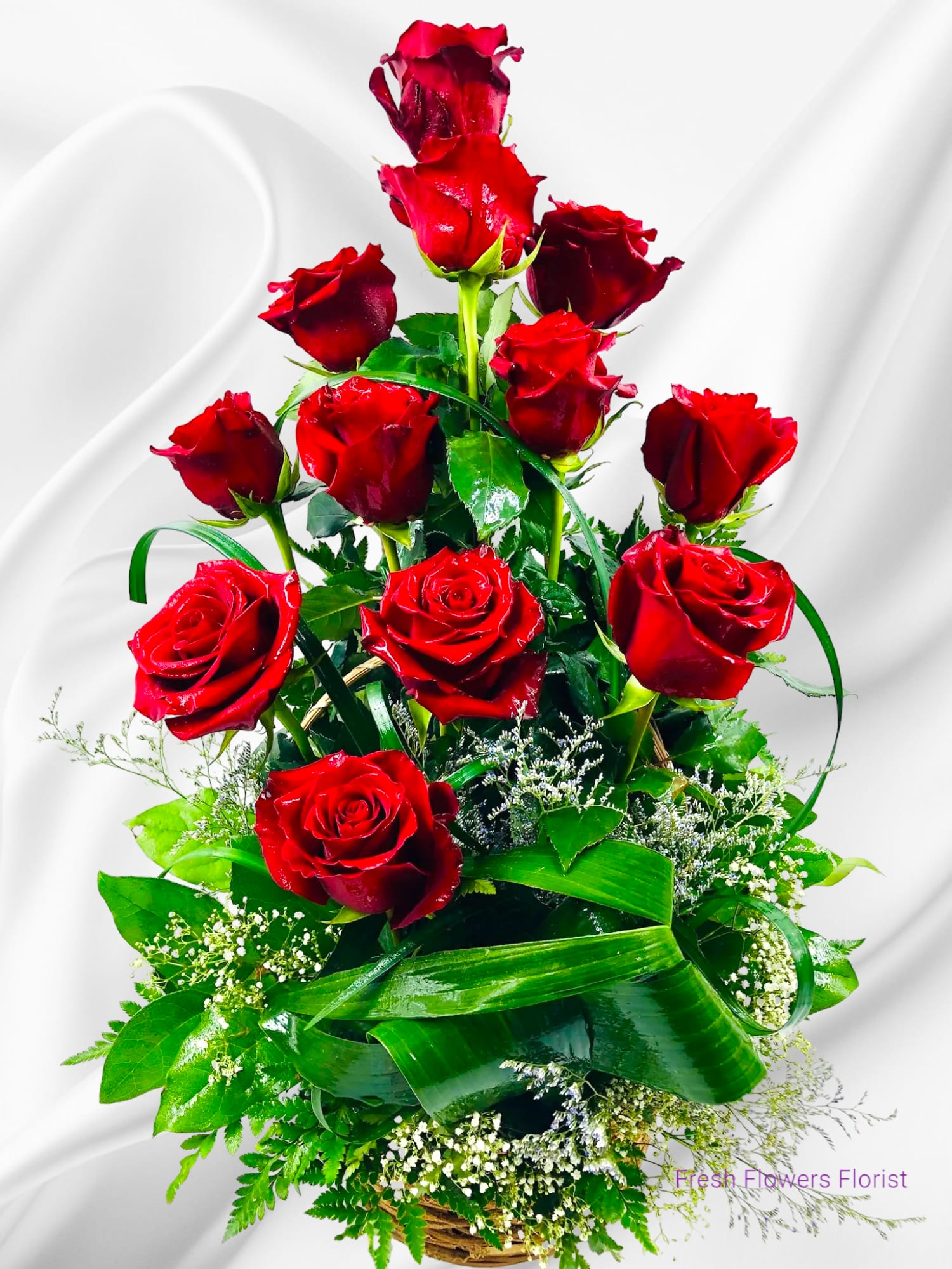 Tall basket arrangement of red roses with greenery