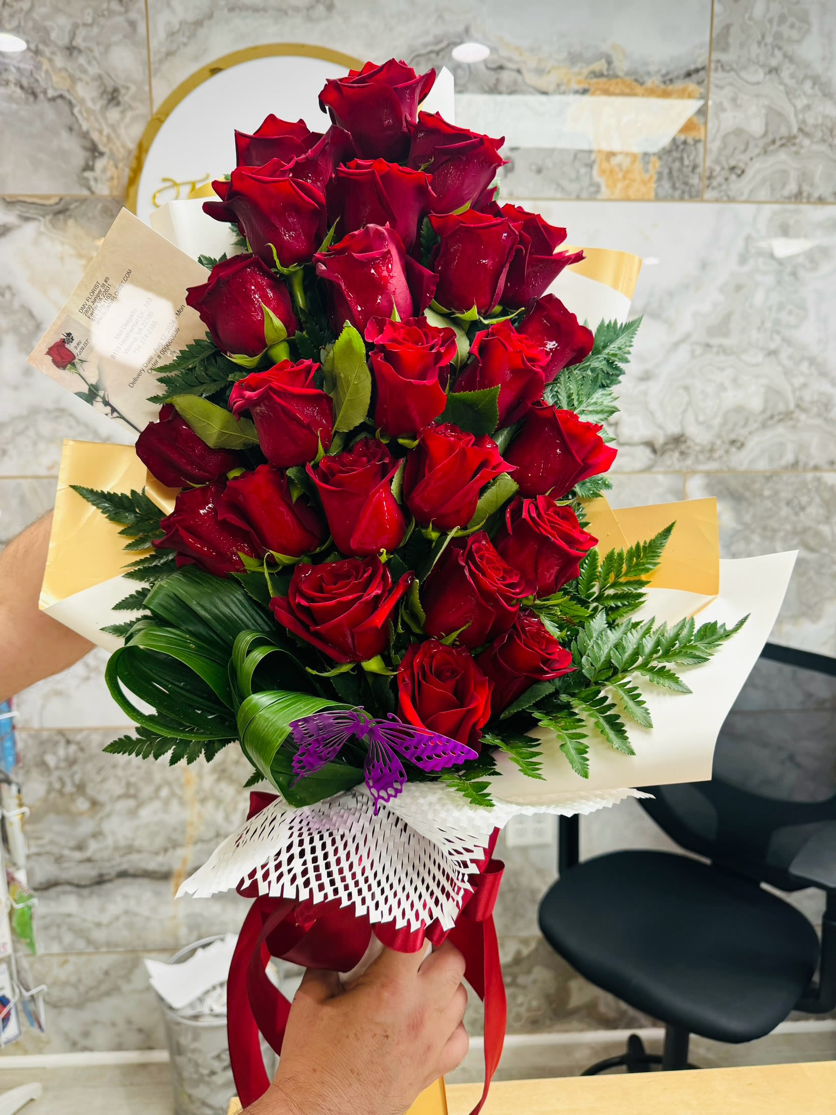 Bouquet of red roses wrapped with white and gold paper
