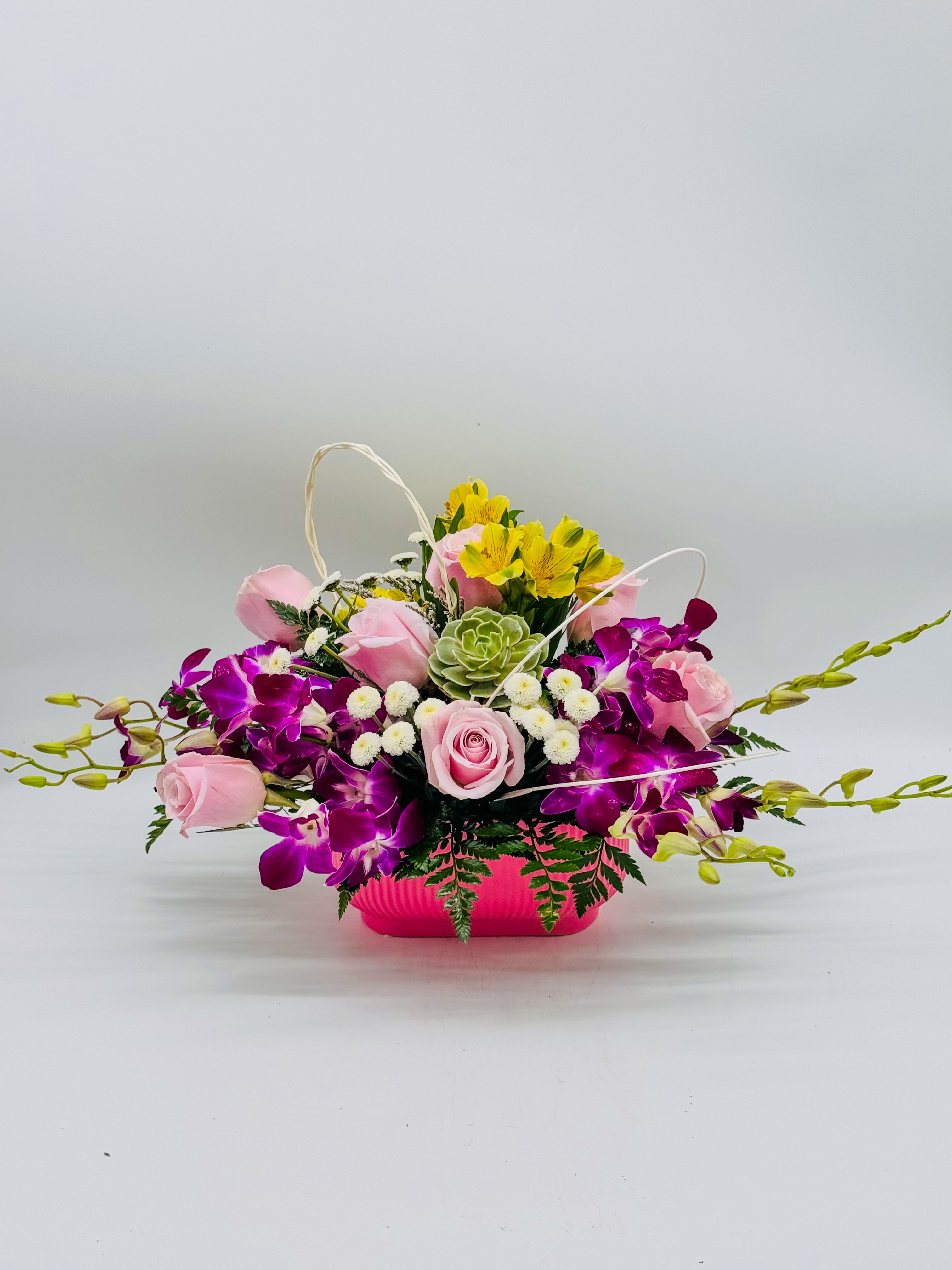 Blossom Symphony  - happy explosion: soft blush-pink roses tucked among bold purple dendrobium orchids, sunny yellow alstroemeria pops, tiny white pompons a one of cute green succulents for that fresh touch, and long graceful green stems trailing out like they’re dancing. Ferns peek through for texture—makes it feel alive, not stiff. Super cheerful, perfect for a birthday, “just because,” or even a baby shower. Kinda screams “smile!, perfect for  birthdays,  get well, just because, thank you , I'm sorry , Mother's Day