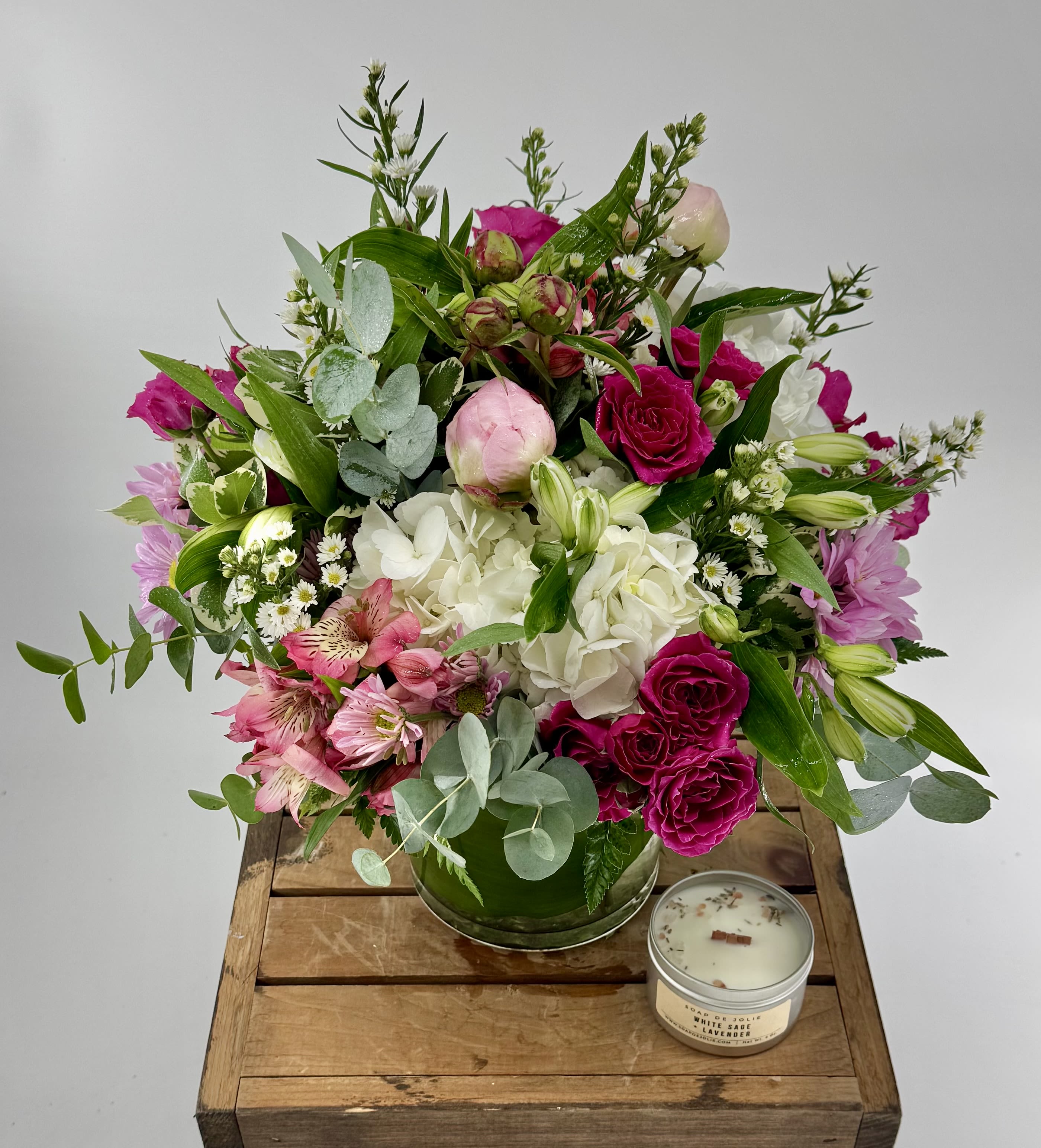 Peony Harmony ( DB) - Elevate your space with this modern flower arrangement, showcasing peonies, hydrangeas, spray roses, and eucalyptus. Professionally crafted and nestled in a stylish leaf-lined glass cylinder vase, it offers a fresh, elegant centerpiece perfect for any contemporary setting.