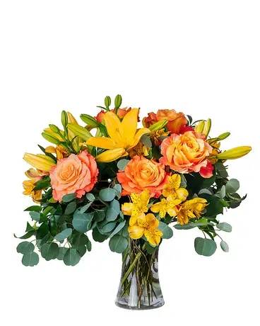 Bouquet of orange roses and yellow lilies in a glass vase