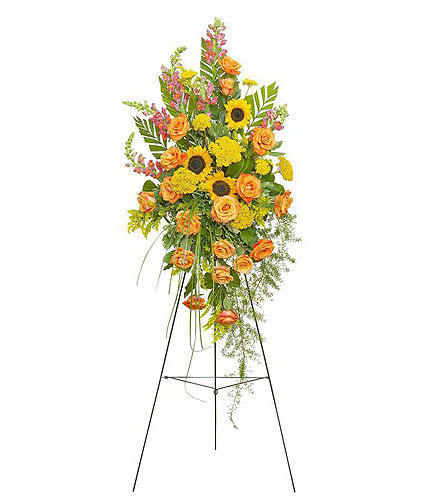 Tall floral standing spray with orange roses and yellow sunflowers on a metal easel