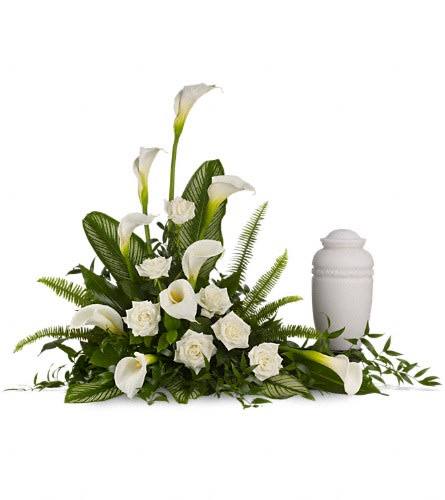 The Statement - A calming portrait in ivory. Majestic calla lilies and stately white roses are framed by the lush leaves of aspidistra and calathea. Soft green sword fern adds to the soothing tones. Large white calla lilies pair with white roses and lush greens that include soft airy sword fern and glossy aspidistra. Please note: Arrangement does not include urn.Approximately 41" W x 31" H Orientation: One-Sided As Shown : DG2171A